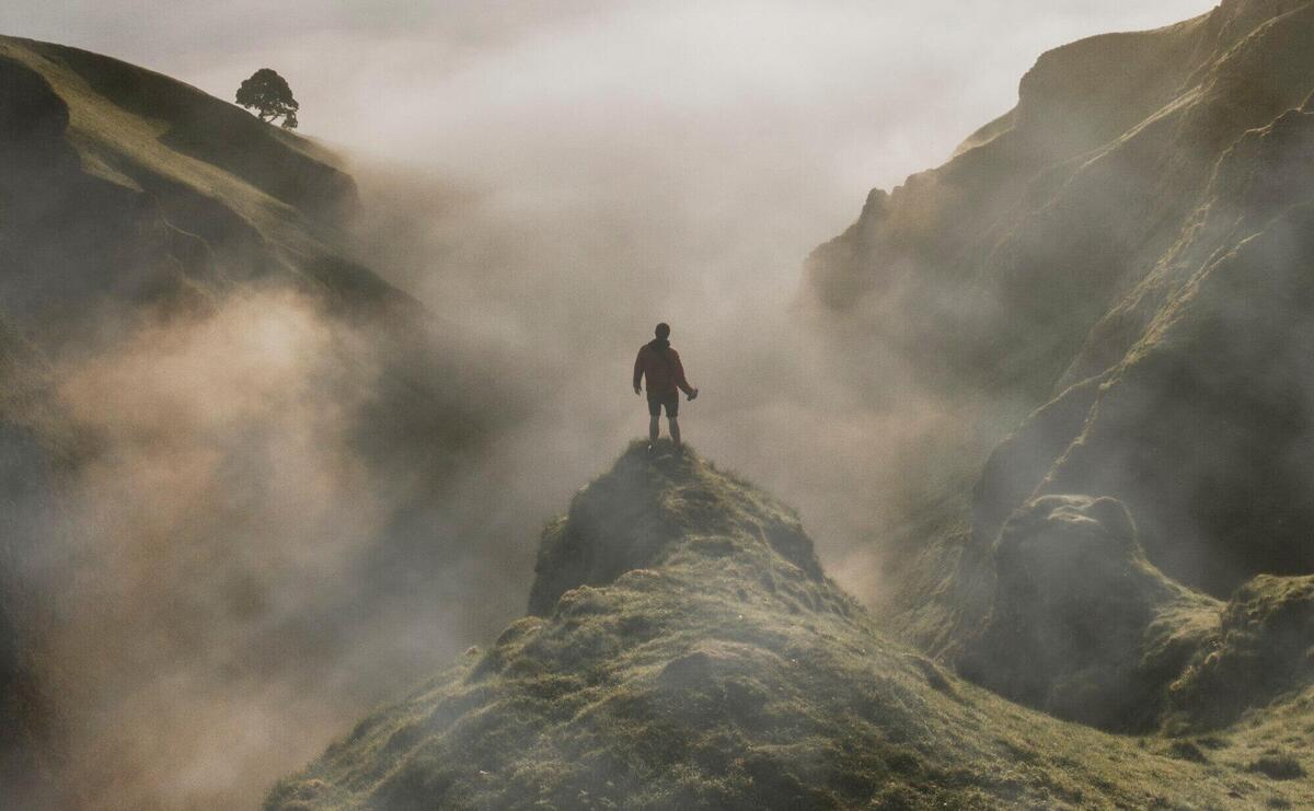 Man standing on cliff with fog overlay texture