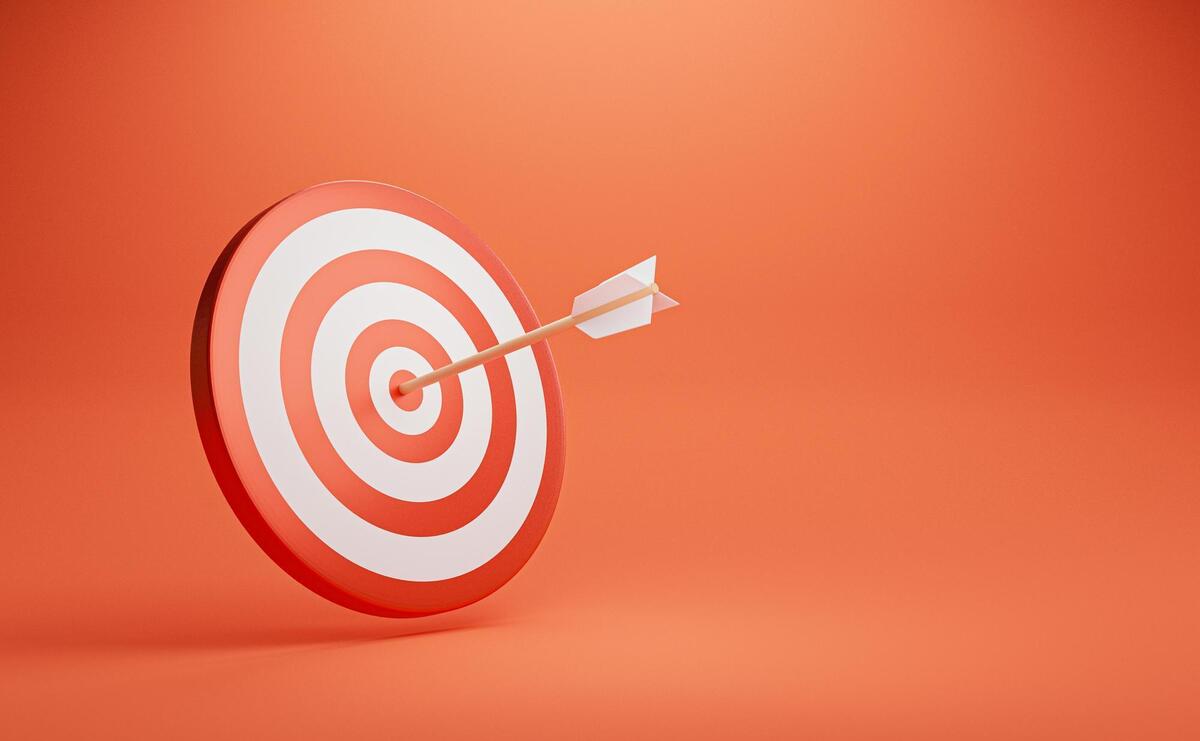 Dartboard with arrow on red background for symbol of setup business objective and achievement target.