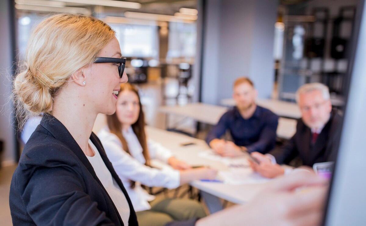 Close-up of blonde young businesswoman giving presentation in the meeting