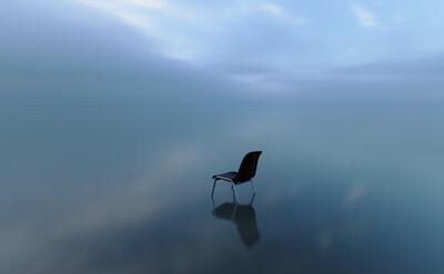 Single chair reflecting on a water surface on a stormy day