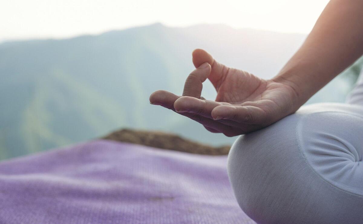 Beautiful young woman meditating and exercising on top of him.