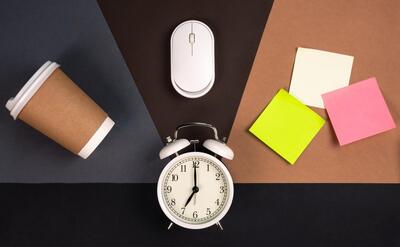 Alarm clock computer mouse paper cup and bright paper stickers top view