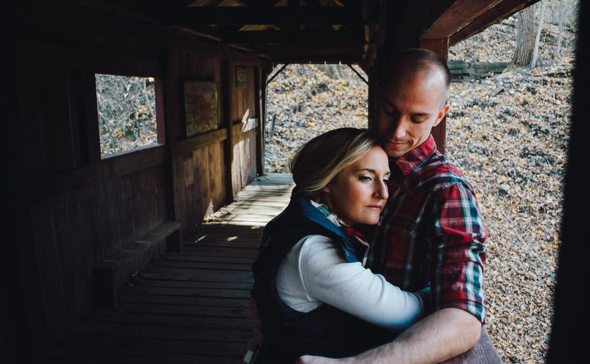 woman hugging man inside bridge during daytime