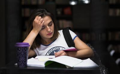 Girl sitting at table with notebooks reading