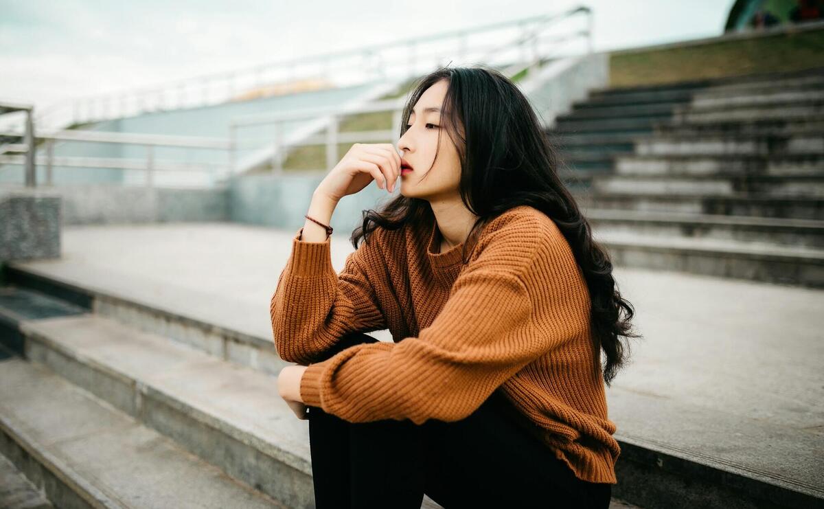 woman wearing brown sweater holding lips