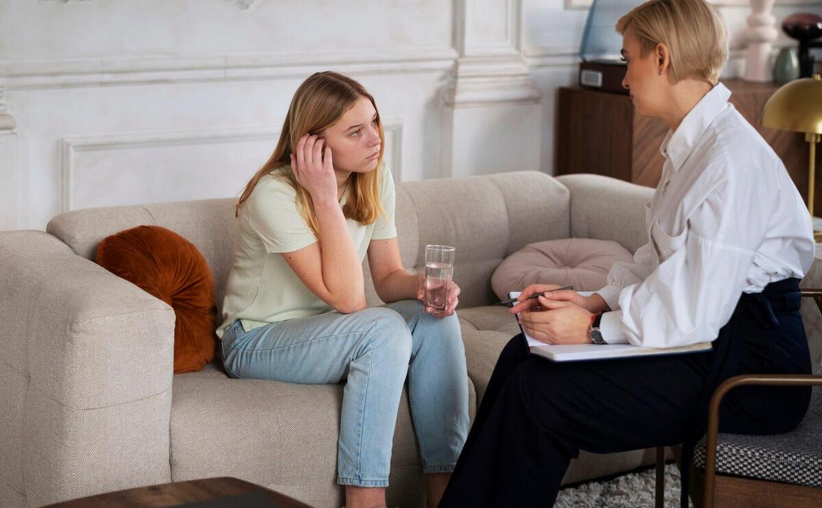 Full shot young girl talking to therapist