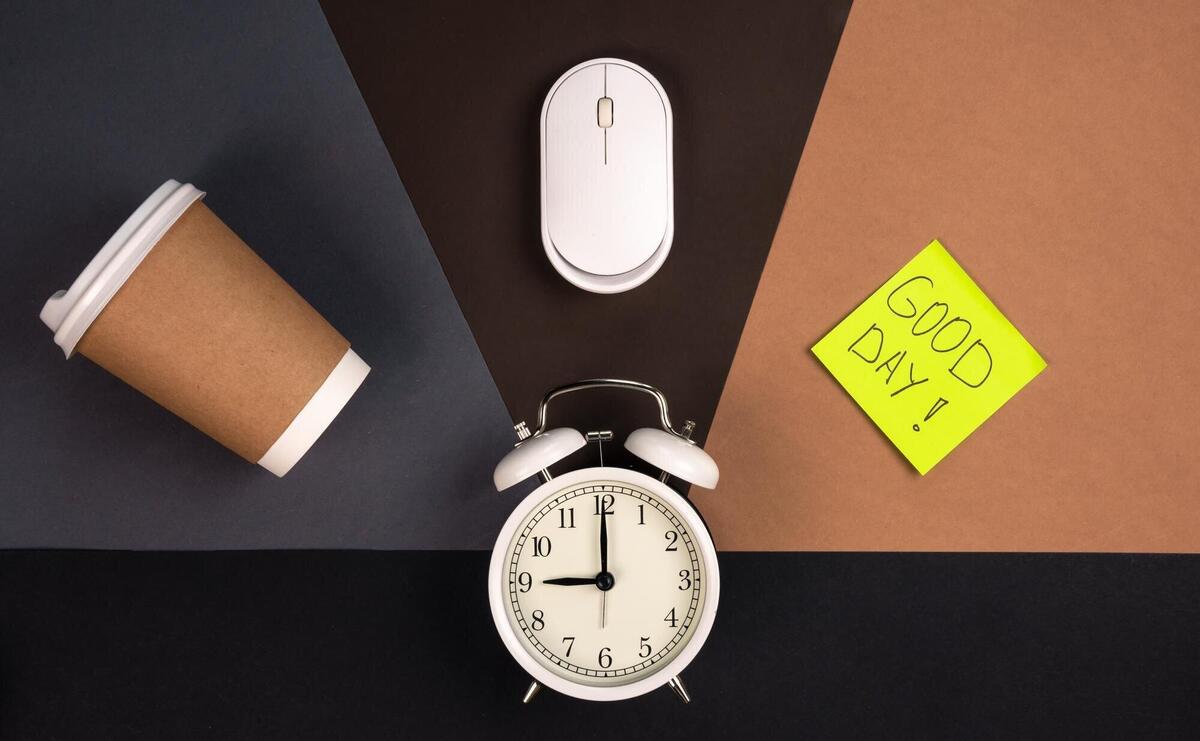 Alarm clock computer mouse paper cup and bright paper sticker top view