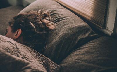 woman sleeping on bed under blankets