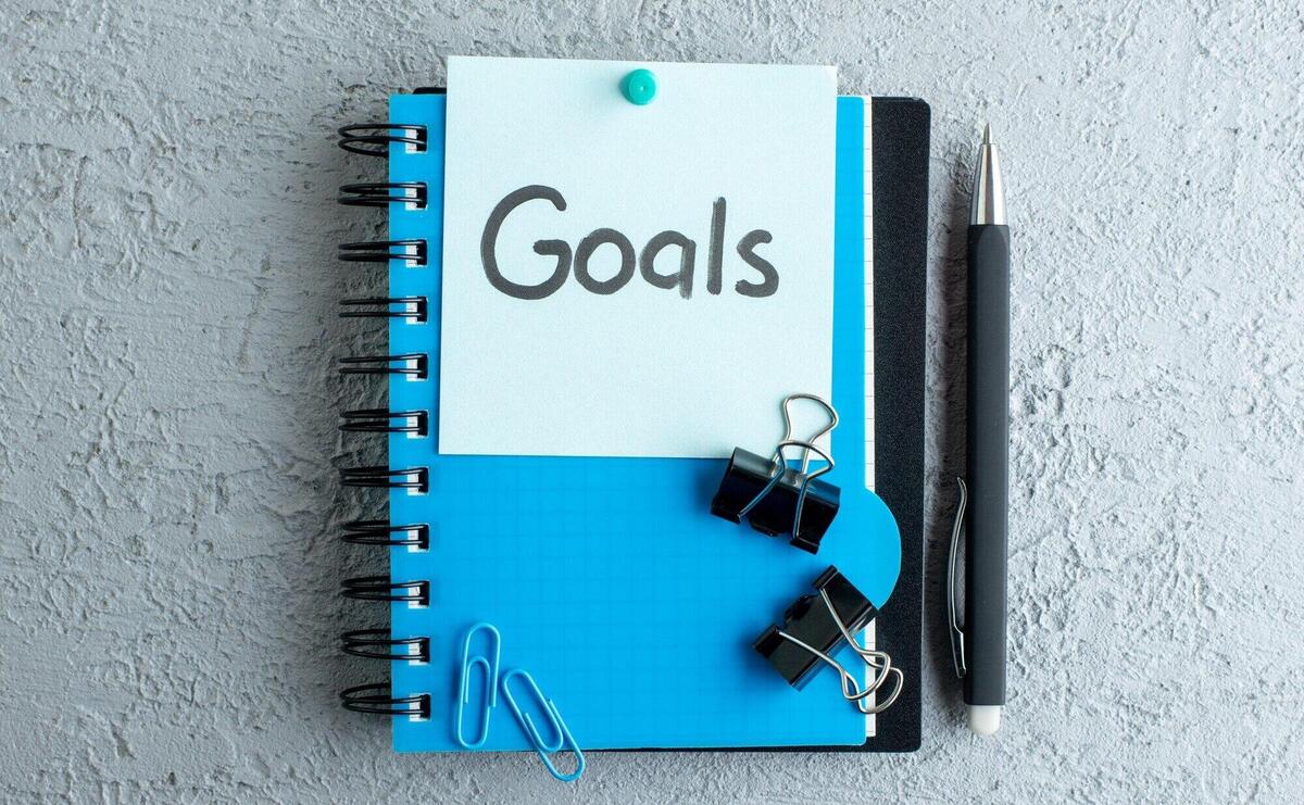 top view goals written note with notepad and pen on white surface color school job business copybook college office