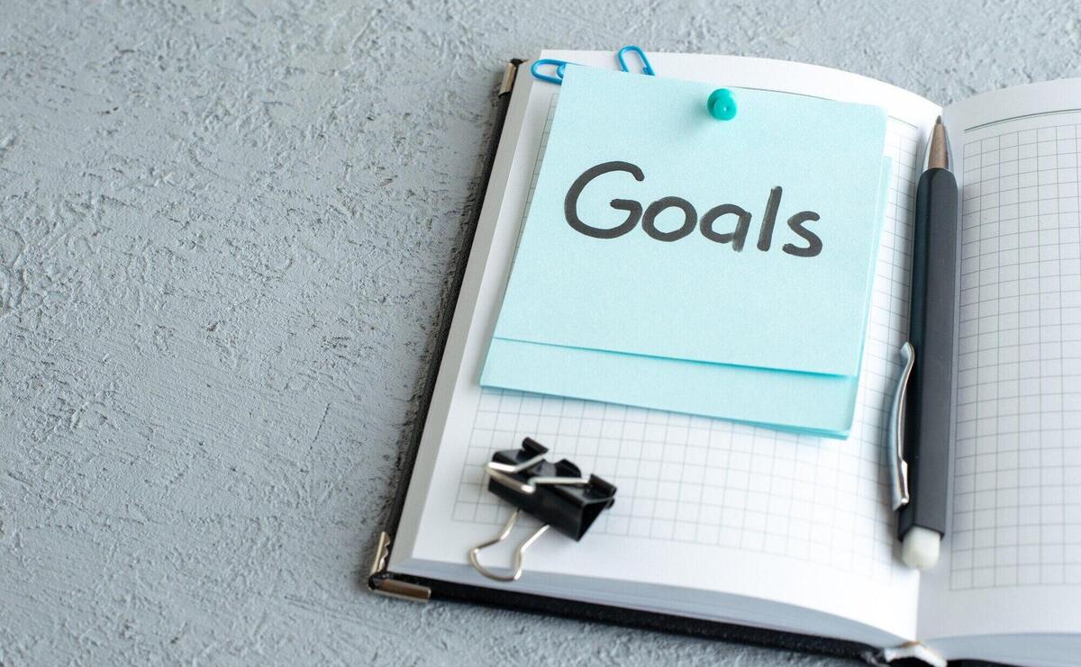 Front view goals written note with pen on white background