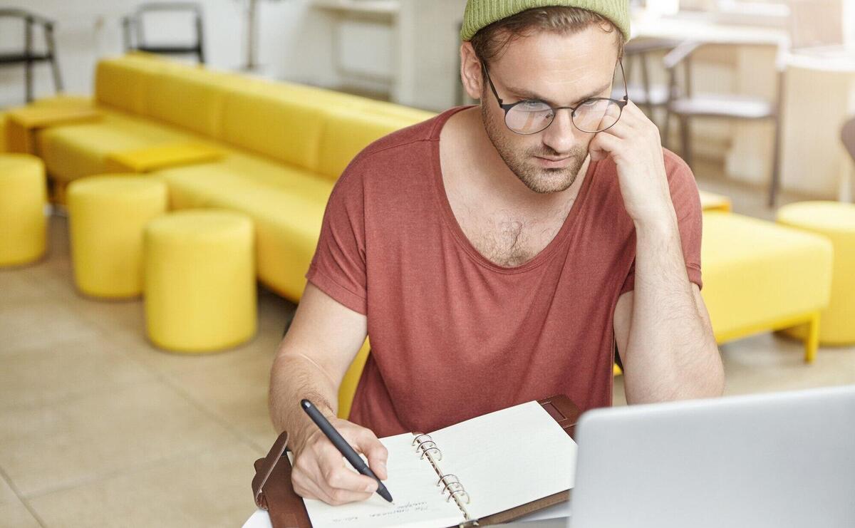 Young man sitting in cafe with laptop