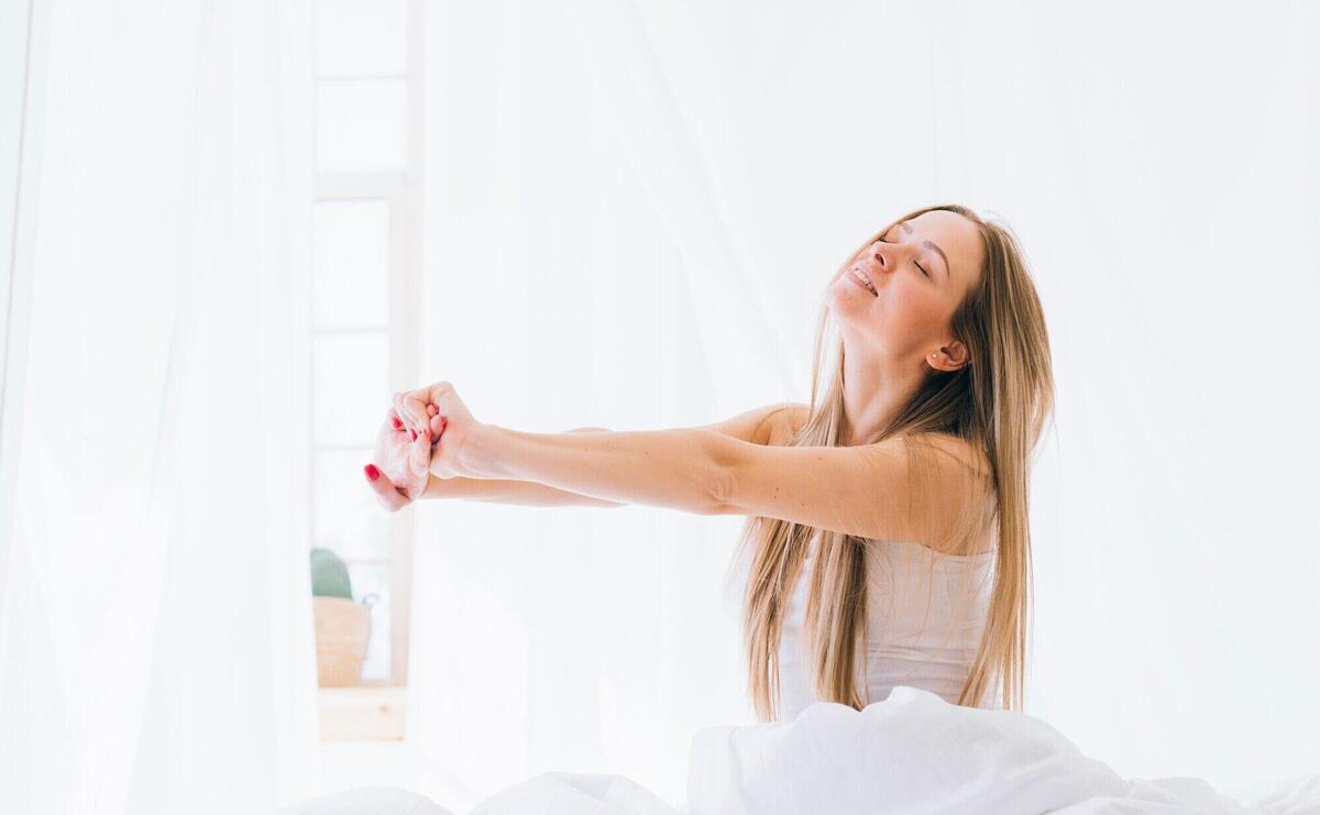 Blonde girl stretching on the bed