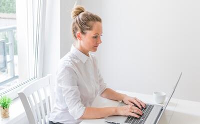 Side view of confident young woman using laptop