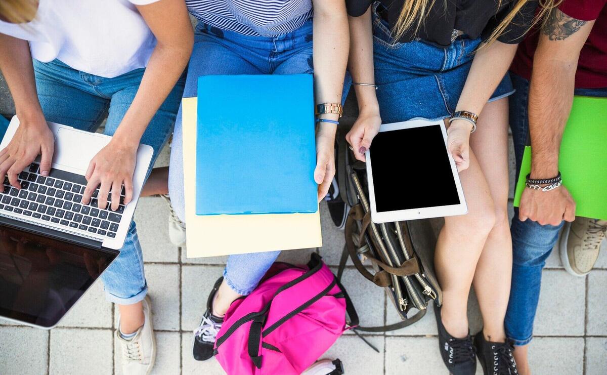 Crop students studying on pavement