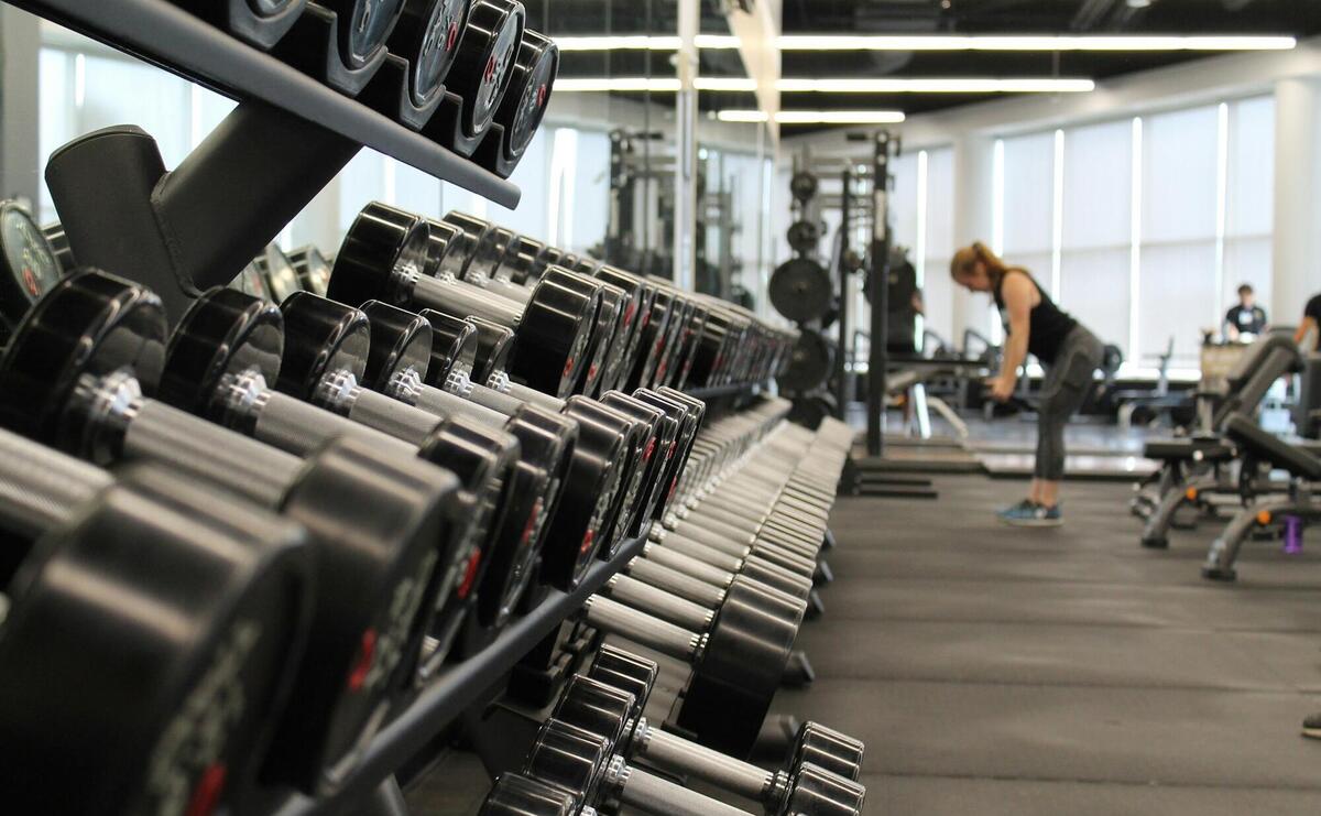 woman standing surrounded by exercise equipment