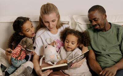 Photograph of a family reading together a book