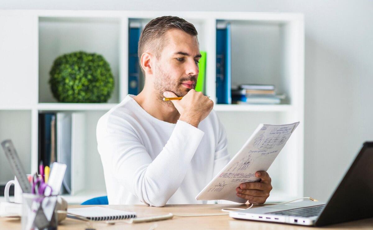 Young businessman looking at document in office