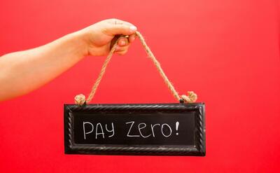 A hand holds a sign displaying 'Pay Zero' on a vibrant red background, emphasizing a free or zero-cost concept.