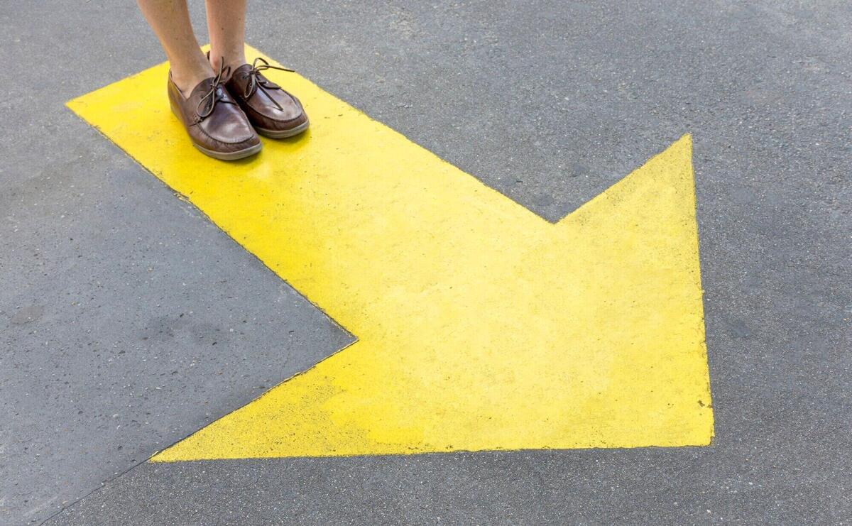 Yellow painted arrow in the streets and legs