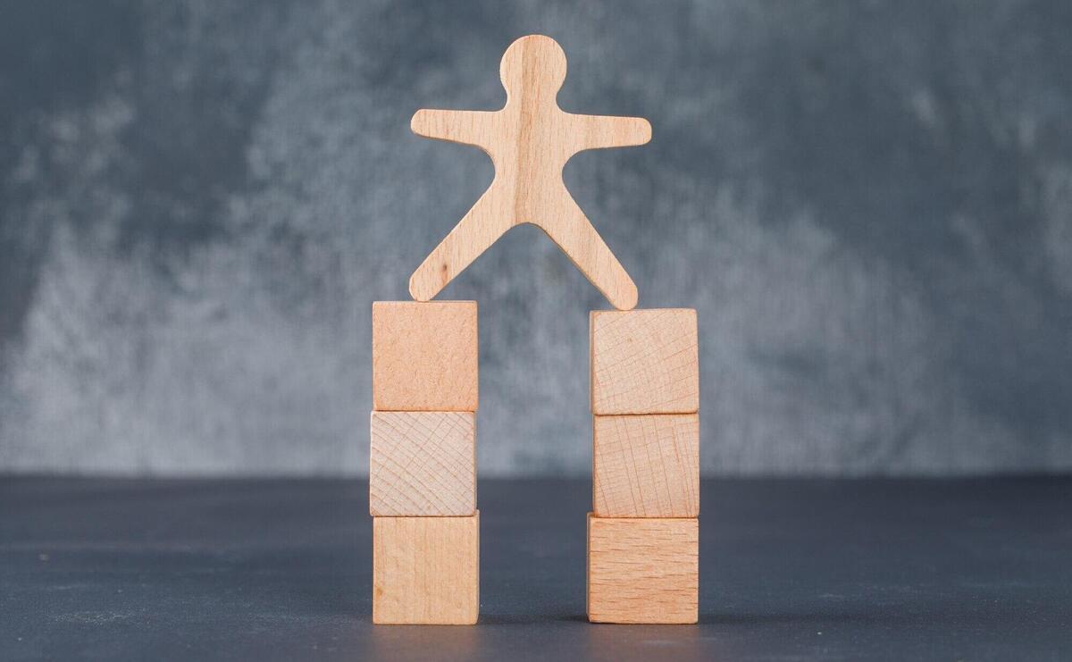 Business concept with wooden blocks with wooden human figure.