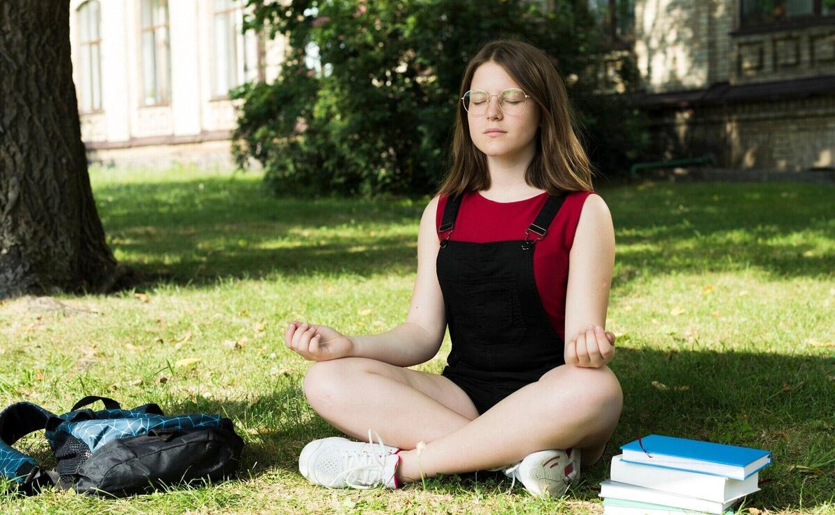 Sideview of meditating highschool girl