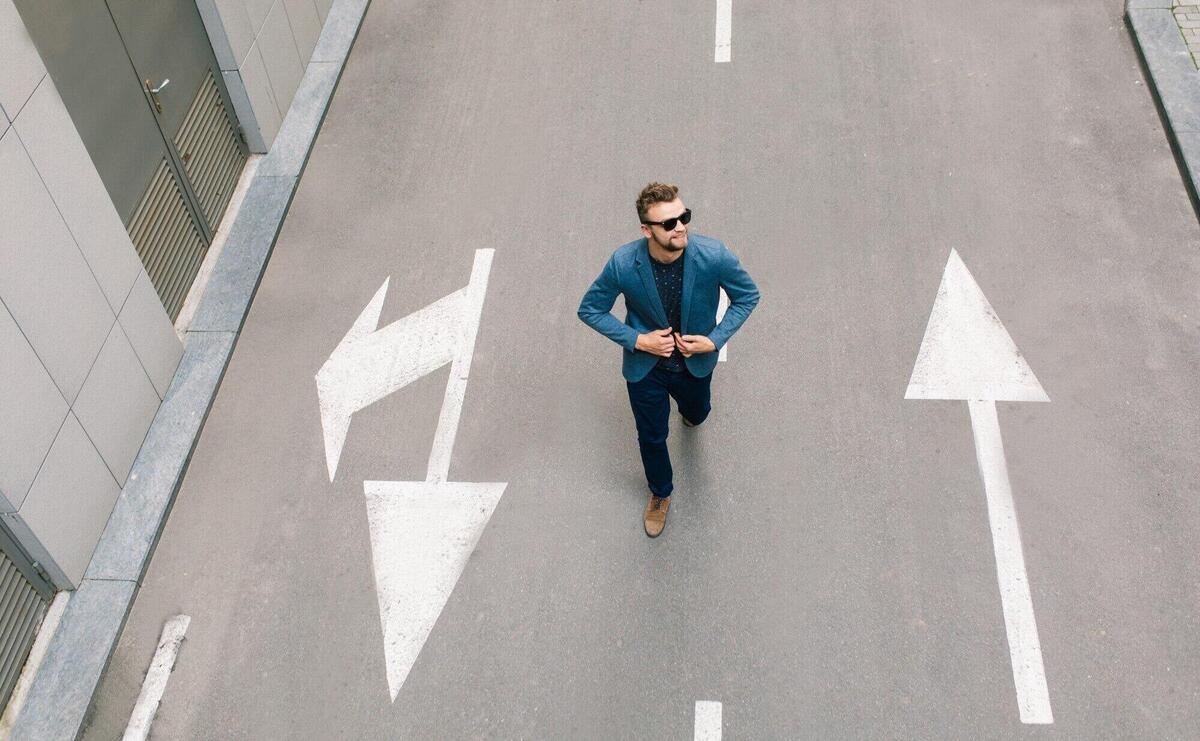 Handsome man in sunglasses is walking on road